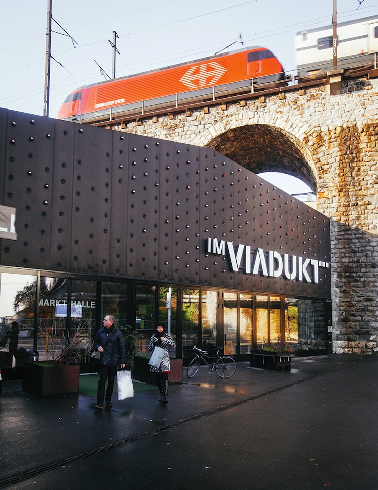 An S-Bahn commuter train passing over Im Viadukt, a stretch of renovated railways arches that now house shops and an indoor market.